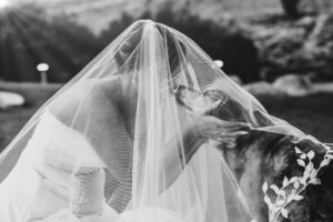 Bride embracing her dog under her veil in Oak Park, California.